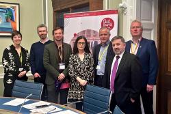 Health Minister Robin Swann stands with members of the All Party Group on Stroke at a room in Stormont Parliament Buildings.