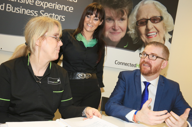 Minister pictured with staff members at Connected Health Belfast
